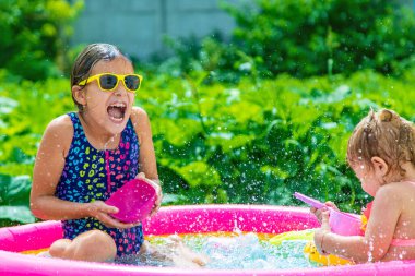 Çocuklar havuzda yüzer. Seçici odaklanma. Çocuk.