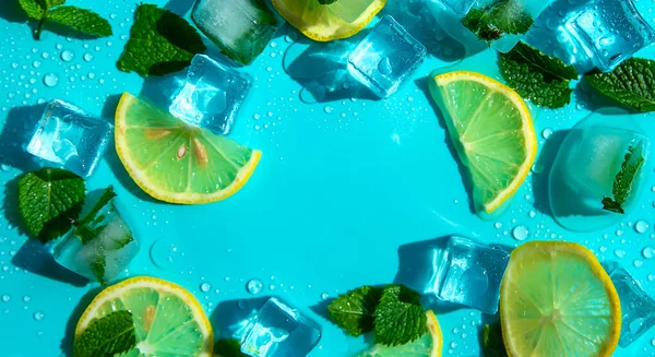 Blue background with mint, lemon and ice cubes. Selective focus. Summer.