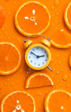 Clock and citruses summer time concept. Selective focus. Food.