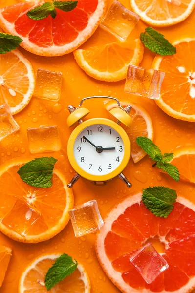 Clock and citruses summer time concept. Selective focus. Food.