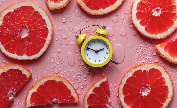 Clock and citruses summer time concept. Selective focus. Food.