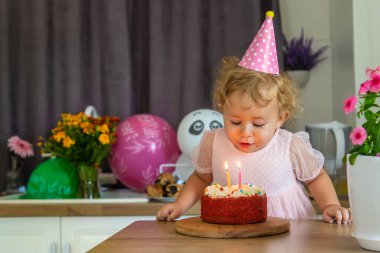 Child is two years old with a cake and candles. Selective focus. Kid.