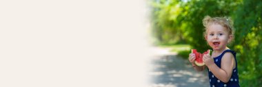 A child eats watermelon in the park. Selective focus. Kid.