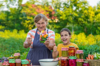 Women with jar preserved vegetables for the winter mother and daughter. Selective focus. Food.