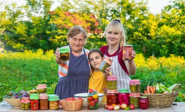 Women with jar preserved vegetables for the winter mother and daughter. Selective focus. Food.