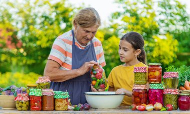 Women with jar preserved vegetables for the winter mother and daughter. Selective focus. Food.