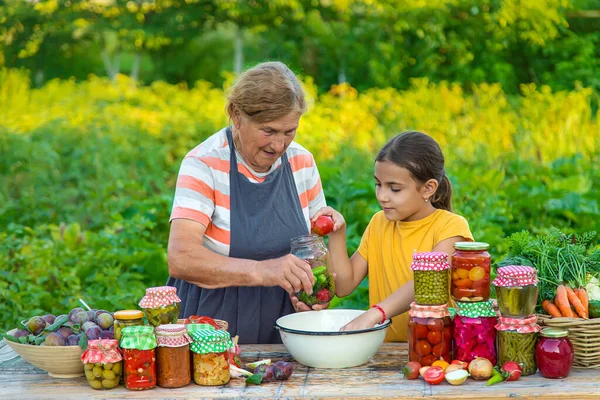 Women with jar preserved vegetables for the winter mother and daughter. Selective focus. Food.