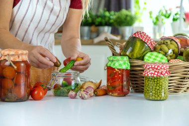 Woman jar preserve vegetables in the kitchen. Selective focus. Food.