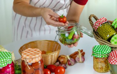 Woman jar preserve vegetables in the kitchen. Selective focus. Food.