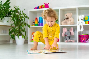 Children are reading a book in the room. Selective focus. Kid.