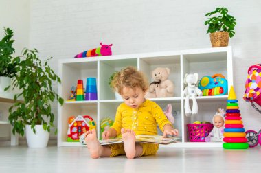 Children are reading a book in the room. Selective focus. Kid.