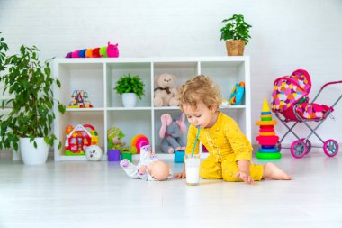 Child drink milk in the room. Selective focus. Kid.