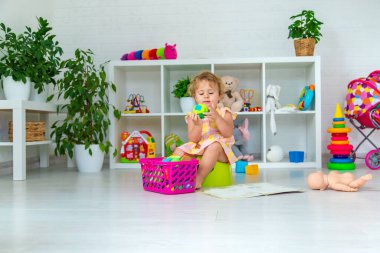 Children sit on the potty in the room. Selective focus. Kid.