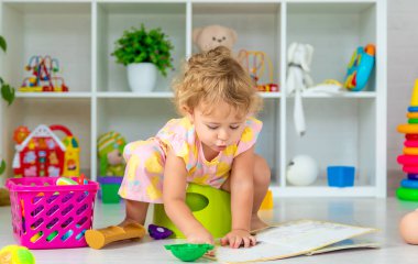 Children sit on the potty in the room. Selective focus. Kid.