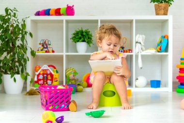 Children sit on the potty in the room. Selective focus. Kid.