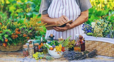 Grandmother makes tinctures from medicinal herbs. Selective focus. People.