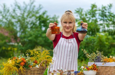 Woman with medicinal herbs and tinctures. Selective focus. Nature.