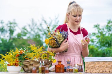 Woman with medicinal herbs and tinctures. Selective focus. Nature.