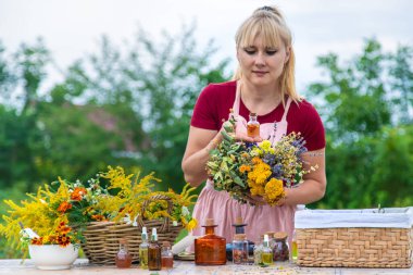 Woman with medicinal herbs and tinctures. Selective focus. Nature.