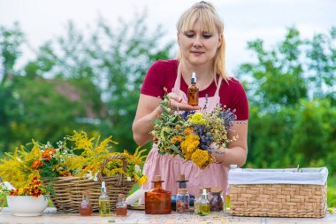 Woman with medicinal herbs and tinctures. Selective focus. Nature.
