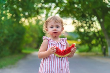 Küçük kız yazın karpuz yer. Seçici odaklanma. Yiyecek..