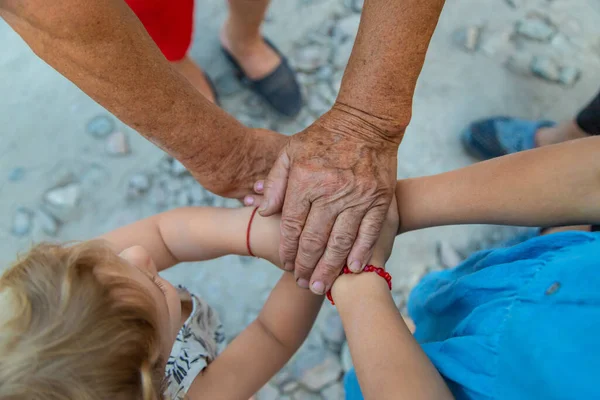 Grandmother and grandchildren friends hands together. Selective focus. People.