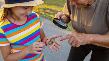 The child is playing with the frog. Selective focus. Kid.
