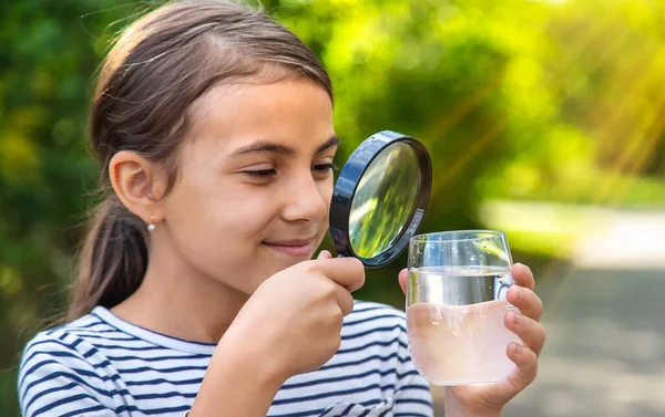 Criança Examina Água Com Uma Lupa Foco Seletivo Miúdo — Fotografia de Stock