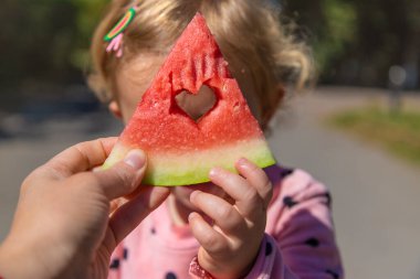 The child eats watermelon in summer. Selective focus. Kid.