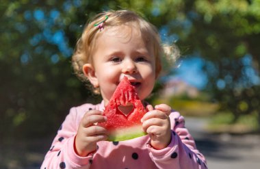 The child eats watermelon in summer. Selective focus. Kid.