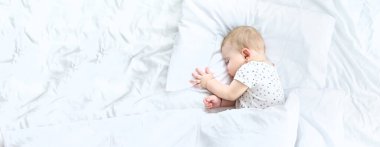 Bebek beyaz bir yatakta uyuyor. Seçici odaklanma. Çocuk.