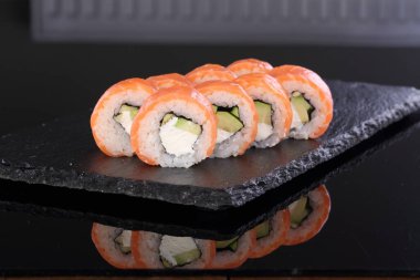 Peynirli somon. Siyah arka planda rulo ve suşi