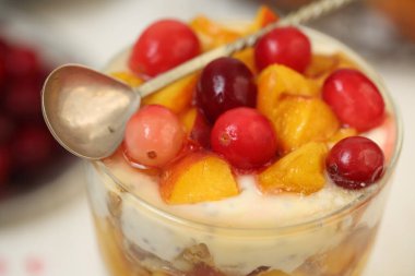 Beyaz tabakta ricotta, şeftali ve kızılcıklı tatlı.