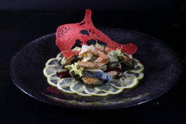 Limonlu midye ve karides. Siyah arka planda deniz ürünleri