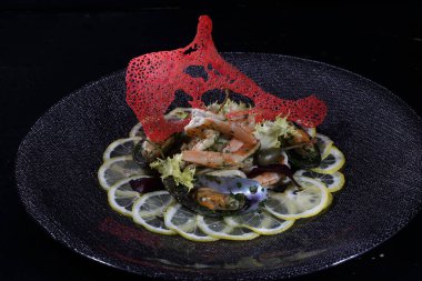 Limonlu midye ve karides. Siyah arka planda deniz ürünleri