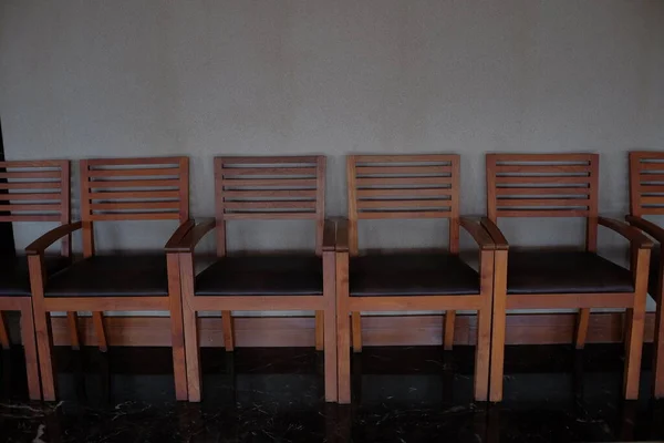 Klasik kahverengi minimalist tasarımı olan sıra sıra sandalyeler..