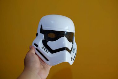 Yogyakarta, Endonezya, Ekim 26, 2021. Bir insanın eli, kurgusal Starwars filmindeki rollerden birine benzeyen bir maske tutar.. 