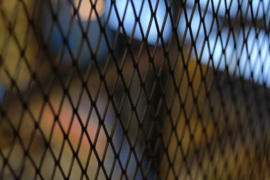 Bulanık ışık arkaplan ile odaklanmış tel örgü engeli. 