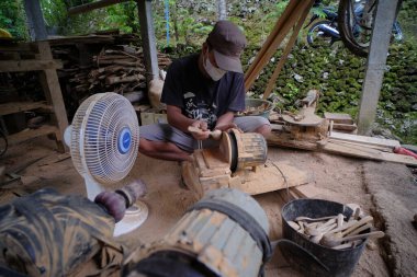 Yogyakarta, Endonezya, 4 Mart 2022. Bir ahşap ustası atölyesinde kaşıklar ve diğer ev ürünleri yapar..