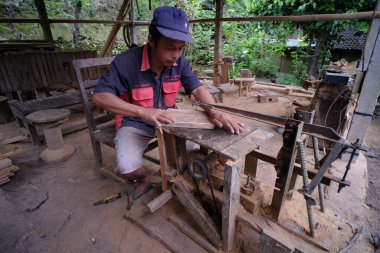 Yogyakarta, Endonezya, 4 Mart 2022. Bir ahşap ustası atölyesinde kaşıklar ve diğer ev ürünleri yapar..