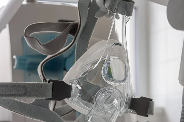 Non-invasive ventilation face mask, on background medical ventilator in ICU in hospital.