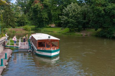 LEDNICE, CZECH REPUBLIC-HAZİRAN 5 HAZİRAN 2020: İnsanlar Lednice-Valtice kompleksi nehrindeki turizm teknesiyle geliyorlar. 