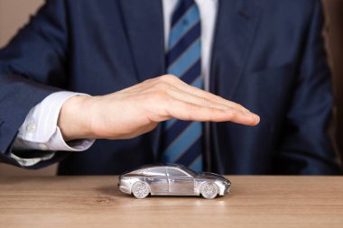 İşadamı el yansıtıcı masa mavi oyuncak araba koruma