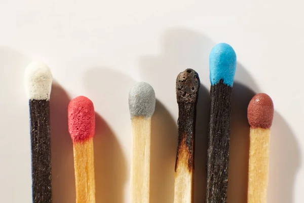 A Few wooden matches with colorful heads on a light gray background close-up. Matchsticks without box. Top view.