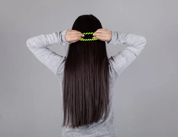 Wanita Muda Mengikat Rambut Latar Belakang Abu Abu — Stok Foto