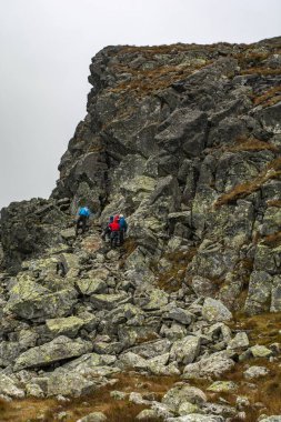 Zakopane, Polonya - 18 Eylül 2021: dağ eğitimi. Eğitmen öğrencilere korunmasız dağ arazisinde güvenli bir şekilde nasıl yol alacakları hakkında bilgi verir..