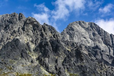 Lomnica Tepesi 'nin (Lomnicky stit, Lomnicky Peak) batı duvarı, öğlen güneşiyle aydınlanan tırmanış rotaları klasikleriyle.