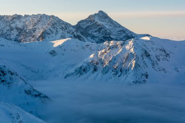 Soğuk ve güneşli bir günde kış manzarası. Vadide bulutlar dolaşıyor.