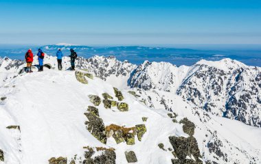 Strbske Pleso, Slovakya - 19 Mart 2022: Tatras 'ta Rysy zirvesinde bir grup turist. Arka planda, Zywiec Beskids 'un en yüksek zirvesi olan Babia Gora' yı (Babia hora) görebilirsiniz..