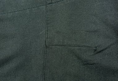 Giysi endüstrisinde kullanılan siyah kumaşa makine dikişleri..